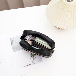 Chic black V-pattern stitched camera bag for women with gold hardware and zipper