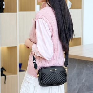 Fashionable black quilted crossbody camera bag with V-pattern and wide logo strap