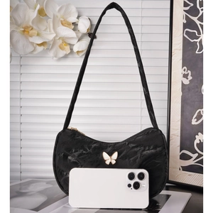 Elegant black pleated hobo underarm bag with white butterfly charm and phone for scale