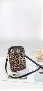 Detail of leopard print crossbody phone bag with gold crown buckle and tassel fringe