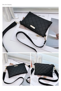 Detail view of black quilted crossbody bag featuring gold hardware and wide woven strap