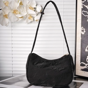 Minimalist black hobo bag with pleated texture and gold zipper in modern home setting