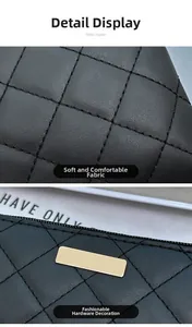 Detail view of black quilted leather with gold metal trim and smooth zipper texture