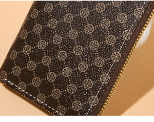 Detail of dark brown vintage coin purse with silver clover print and gold metal zipper