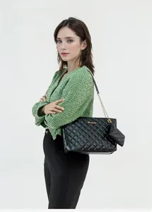 Close-up of black quilted tote bag with golden chain strap and matching mini coin purse