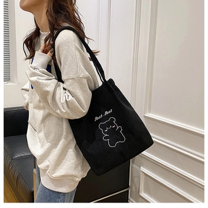 Dettaglio della borsa tote in velluto nero con ricamo di orso bianco e scritta Bear Bear