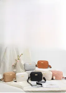 Close-up of quilted V-pattern camera bags in multiple colors with wide fabric straps