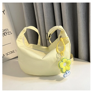 Détail du sac demi-lune en velours côtelé jaune clair avec charm tournesol