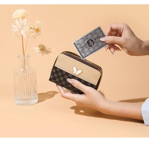 Detail of short wallet with monogram pattern, butterfly charm and VIP card slot