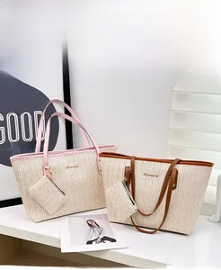 Detail of woven straw tote bag set with metal logo and matching small coin purse