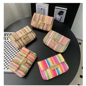 Flat lay of woven straw clutches with colorful stripes and gold metal buckles