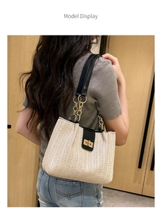 Model display of cream woven tote bag with black leather strap and gold chain detail