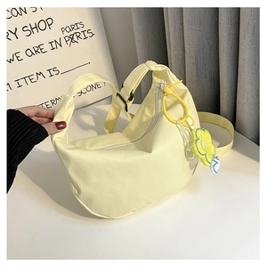 Détail du sac bandoulière demi-lune jaune clair avec breloque marguerite et sangle
