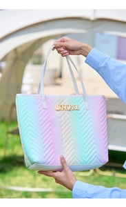 Détail du sac cabas matelassé dégradé avec logo LUCKFORYOU en métal doré sur l'herbe