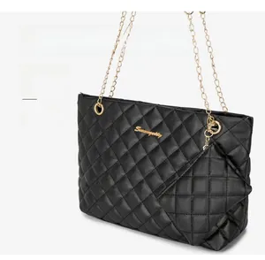 Detail of black quilted tote bag with gold chain strap and matching mini coin purse