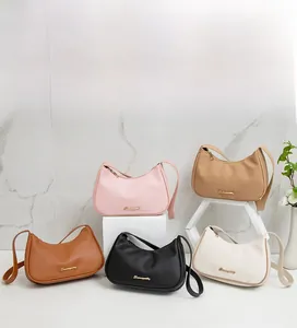 Detail view of five lychee textured underarm bags in various colors on display