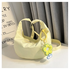 Détail du sac croissant en velours côtelé jaune clair avec breloque fleurie