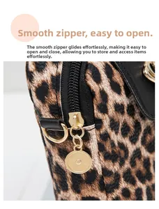 Close-up of leopard print bag featuring a smooth gold zipper and black leather trim