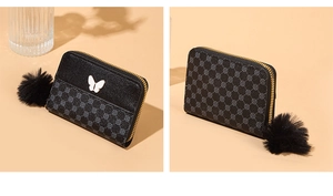 Close-up of small black zip wallet with white butterfly ornament and faux fur keychain