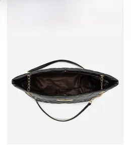 Vertical view of quilted tote bag showing brown lining and golden chain strap detail