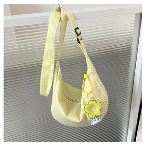 Détail du sac hobo en toile jaune clair avec bandoulière et porte-clés floral