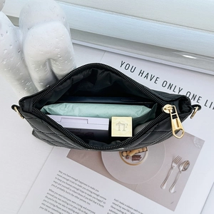 Black quilted crossbody bag showing spacious interior with phone and cosmetics