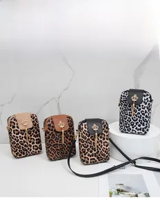 Detailed view of leopard print crossbody bags with gold crown charms and tassels