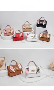 Detail of quilted crossbody bags with silk scarf handles and gold metal turn-lock closures