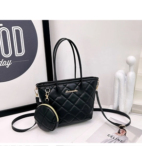 Detail of black quilted basket tote bag with removable round coin purse and gold hardware