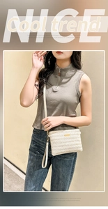 Close-up of beige woven crossbody bag showing V-pattern texture and gold metal plaque