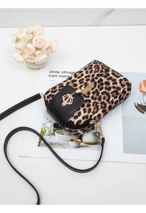 Detail of leopard print phone bag with gold crown pendant and black leather tassel