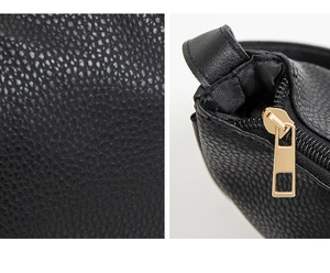 Close-up of black lychee grain texture and gold zipper puller on large shoulder bag