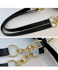 Macro detail of golden metal ring connector on contrast woven tote with black leather strap