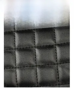 Close-up of black quilted leather texture and detailed stitching on chain tote bag