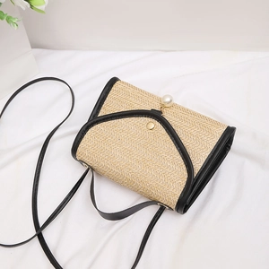 Minimalist straw woven handbag with black leather trim and pearl pendant detail