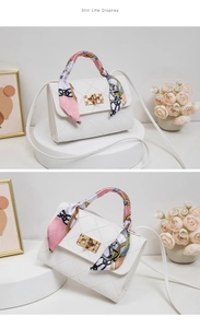 Detail of white quilted crossbody bag with golden twist lock and floral silk scarf handle