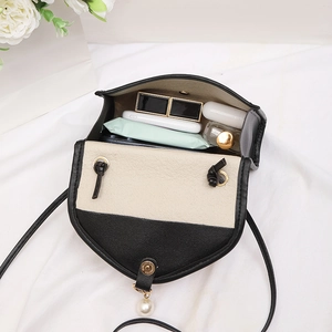 Minimalist black and white woven texture crossbody bag with pearl charm and internal storage