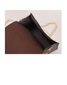 Detail of a brown textured crossbody bag showing internal storage and golden chain strap