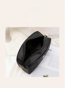 Detail of black quilted camera bag showing premium PU leather texture and gold metal ring