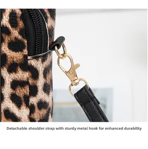 Close-up of leopard print bag with detachable black leather strap and gold hardware