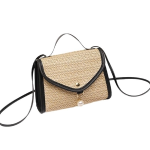 Vintage straw handbag with black leather trim and elegant pearl pendant detail
