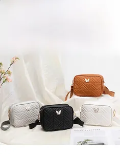 Quilted camera bags in four colors featuring golden butterfly hardware and wide straps