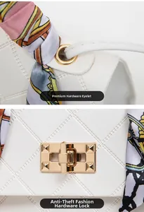 Detail of white quilted handbag with golden twist lock and silk scarf handle decor