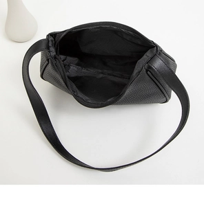 Top view of black pebbled leather crescent bag showing zip closure and interior depth