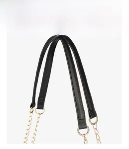Macro shot of black pebbled leather handle with elegant gold chain link hardware detail