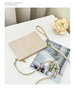Detail of beige woven texture and golden metal logo plaque on the elegant crossbody bag