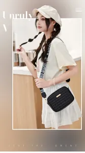 Detail of black quilted crossbody camera bag featuring a patterned wide shoulder strap