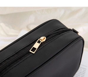 Detail of premium black nylon crossbody bag with durable golden metal zipper closure