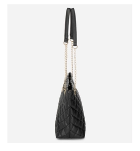 Side view of black quilted tote bag with gold chain strap and elegant stitching