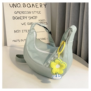 Détail du sac hobo en velours côtelé vert menthe avec fleur jaune et fermeture éclair